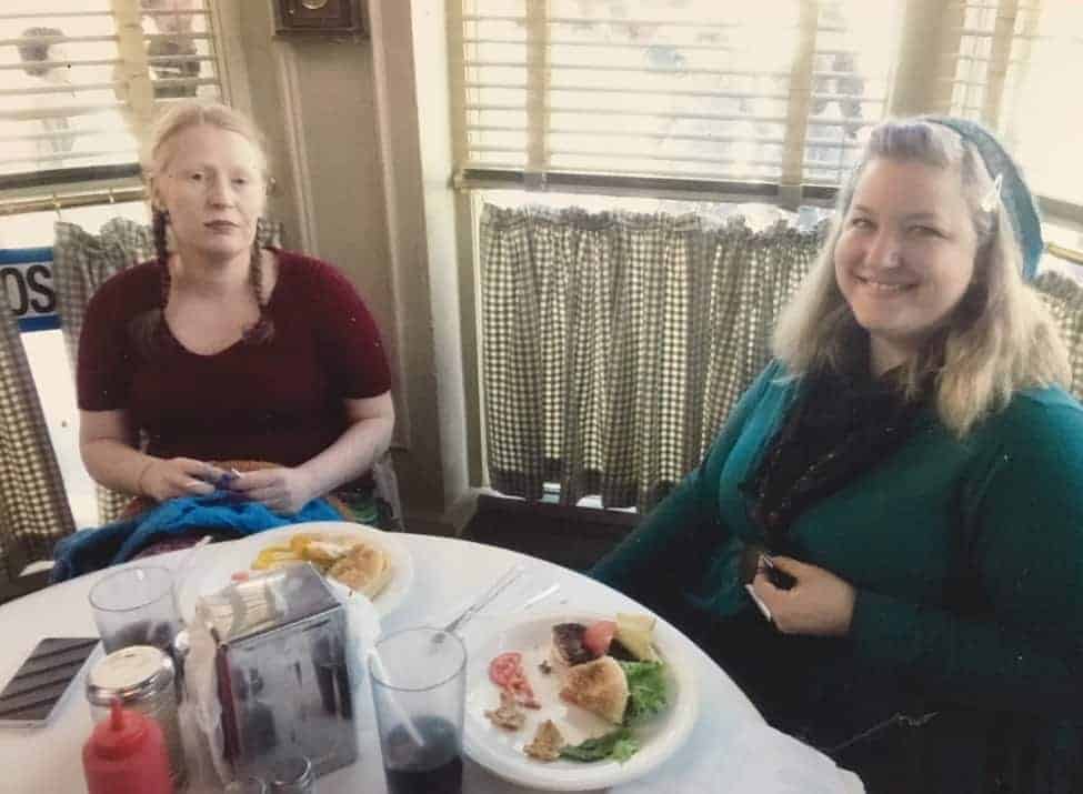 From left, Lucia and Lisa at extras in Luke’s Diner. Lucia almost finished knitting one of their “Split Infinitive” wrap sweaters during the full day it took to film the diner scene in the “Winter” episode.