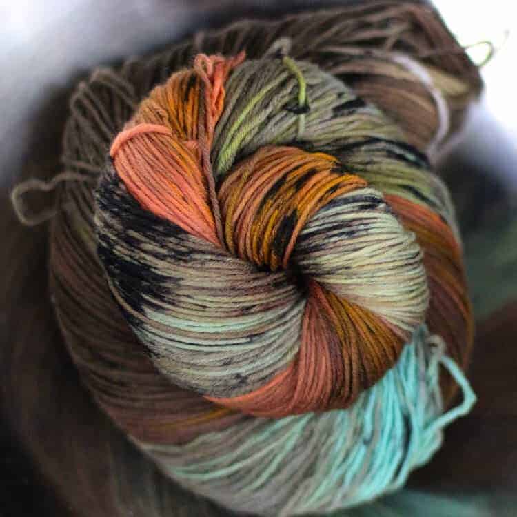 Brown, orange and aqua yarn in a spiral.