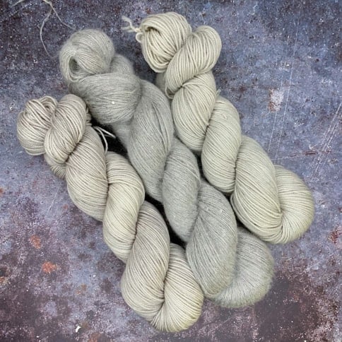 Three skeins of pearly gray yarn.