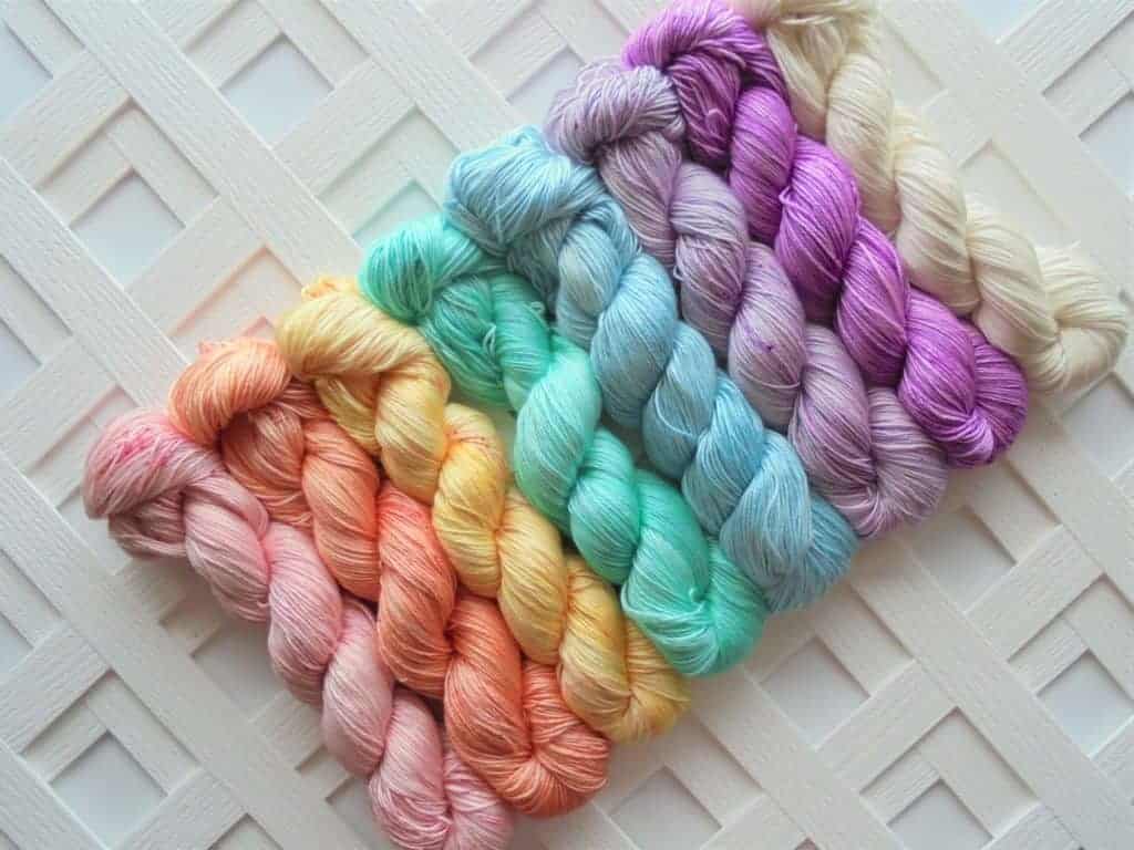 Eight skeins of pastel-colored yarn. 