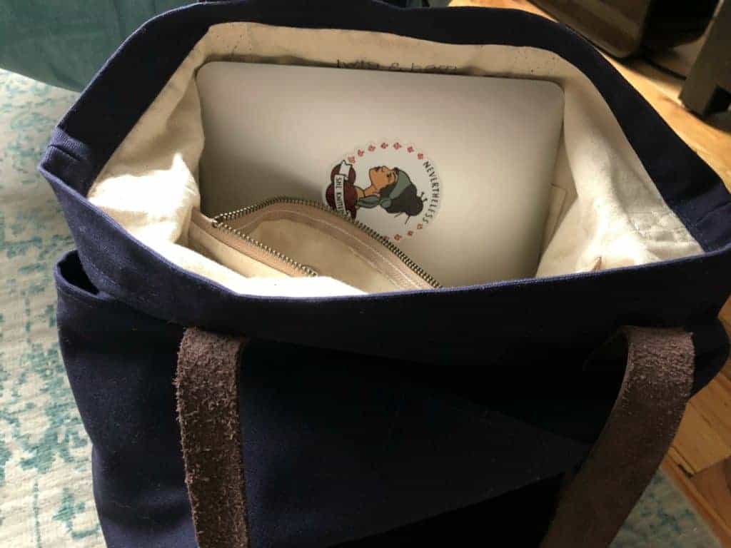 A navy tote with a Macbook inside.