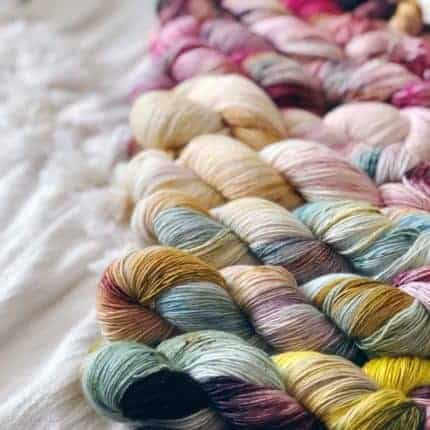 A collection of skeins of pastel hand-dyed yarn.