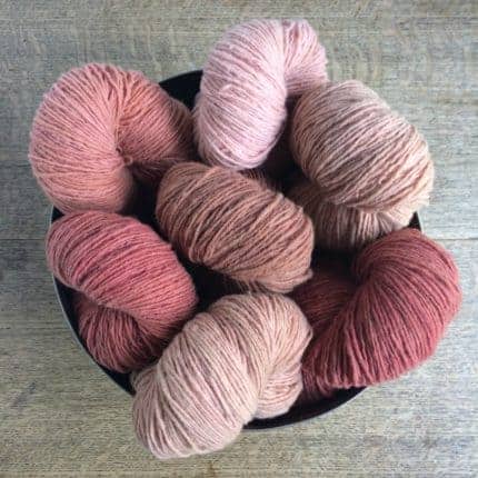 Skeins of various shades of naturally-dyed pink yarn