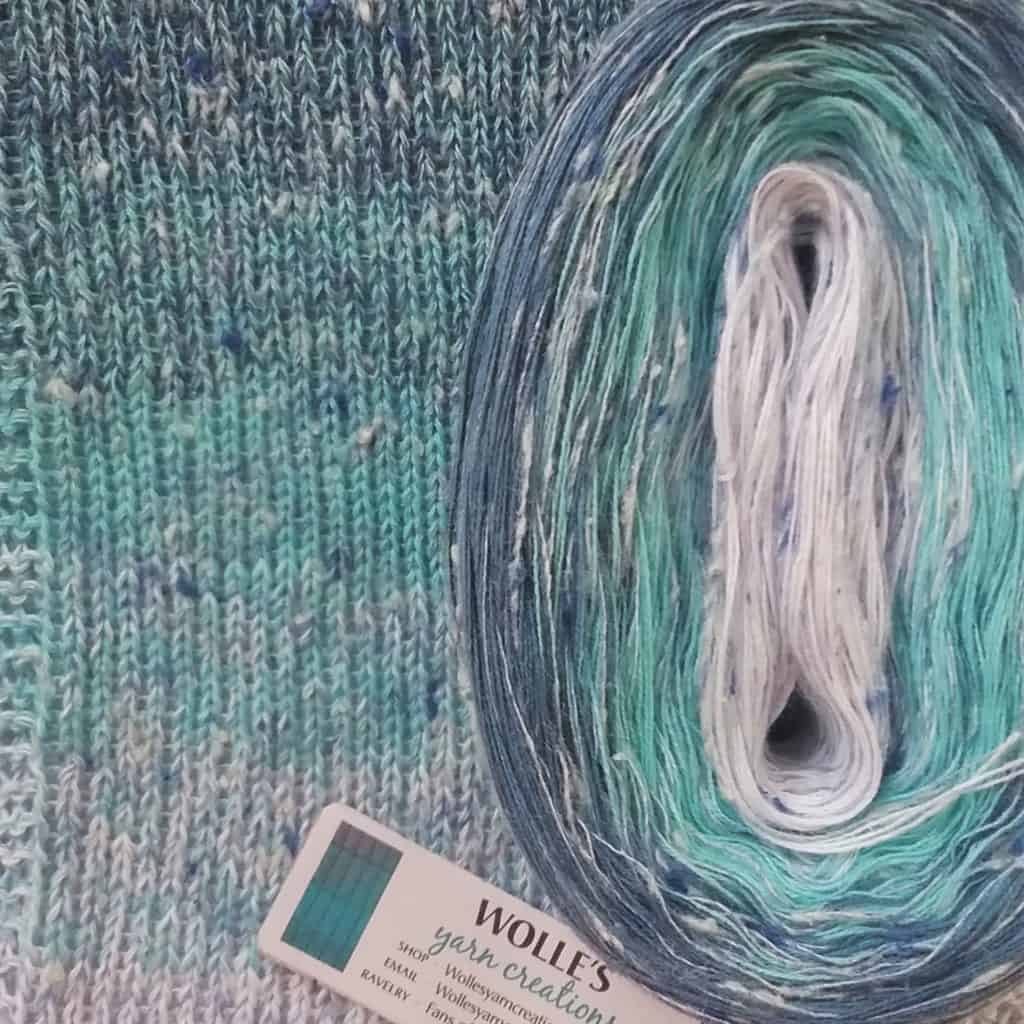 A cake of tweed blue to aqua to cream gradient yarn