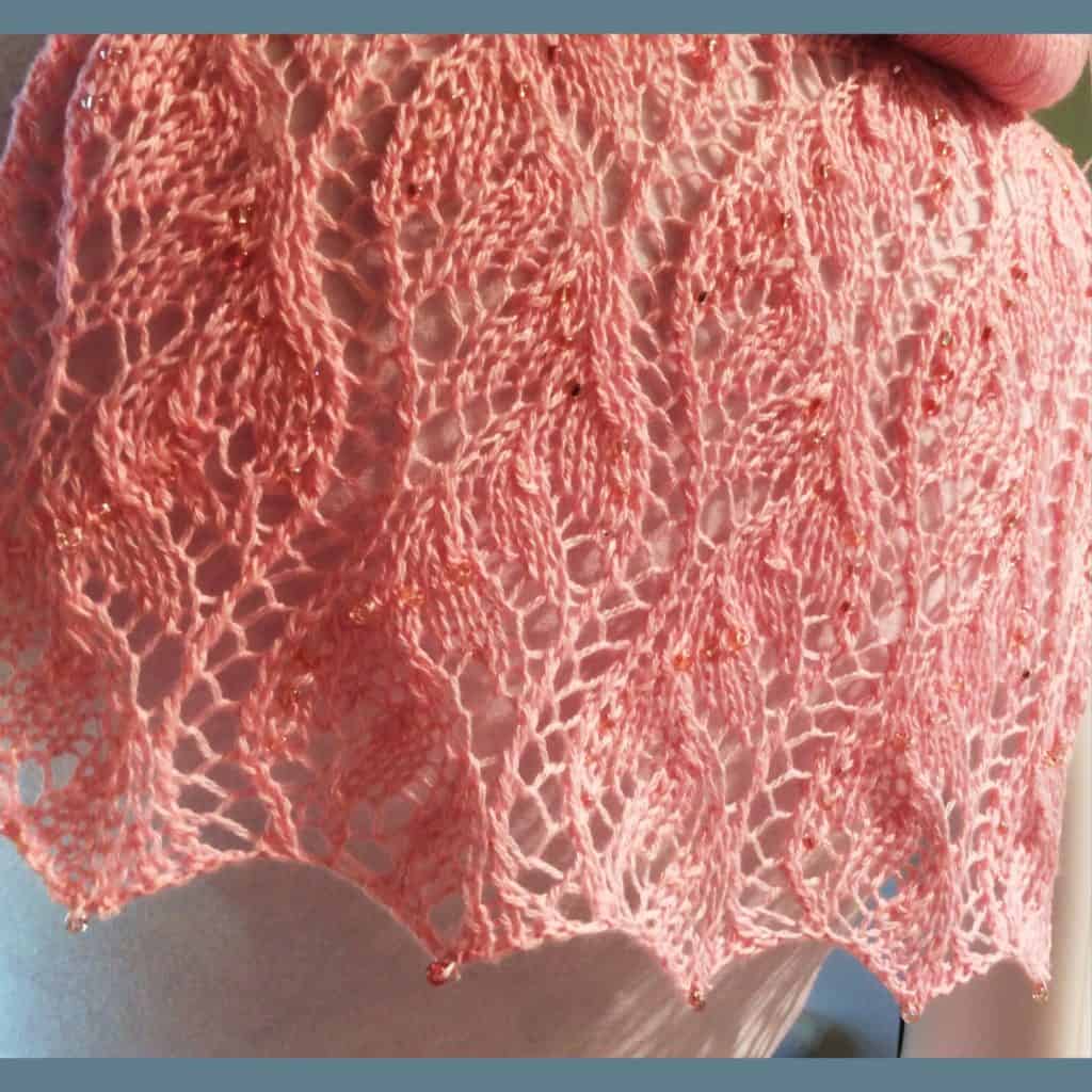 A pink lace scarf with beads.