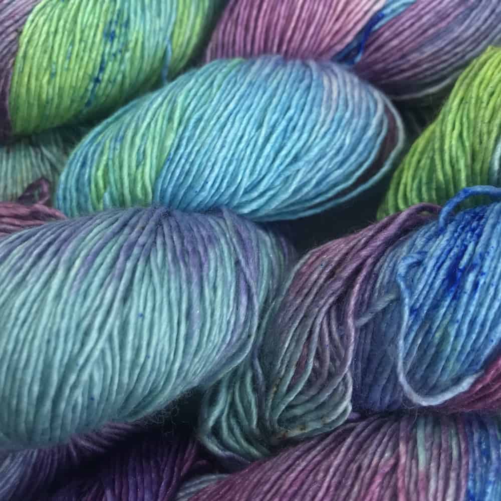 Skeins of bright blue, green and purple yarn.