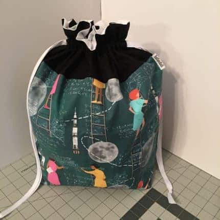 A drawstring bag with women scientist fabric.