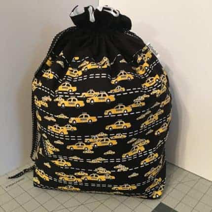 A black drawstring bag with yellow cabs.