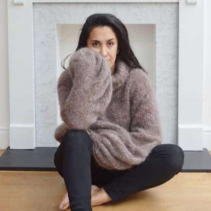A woman models an oversized gray sweater.