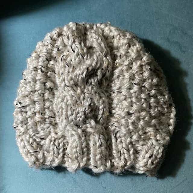 A white cabled hat. 