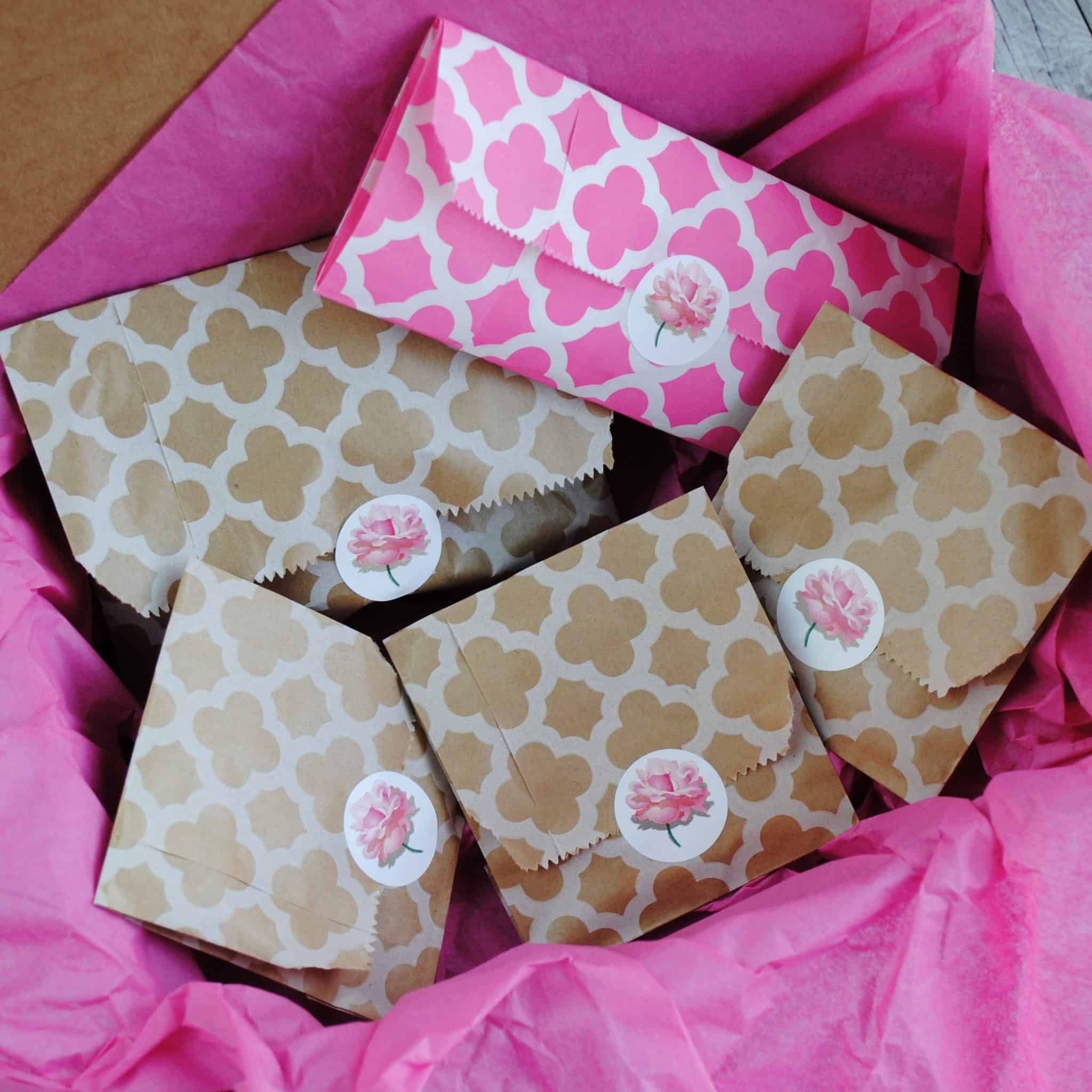 Packages wrapped in pink and kraft tissue paper.