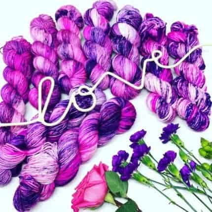 Purple and pink yarn with the word love spelled in rope.