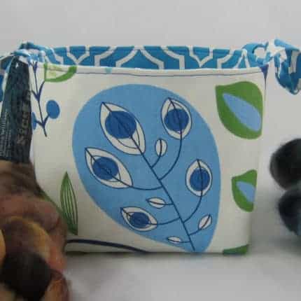 A white bag with a blue and green leaf pattern.
