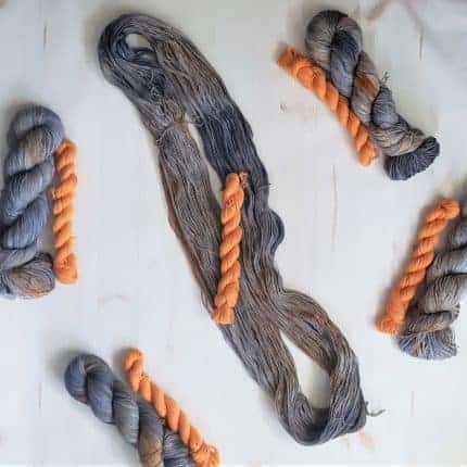 Gray yarn with orange mini skeins.