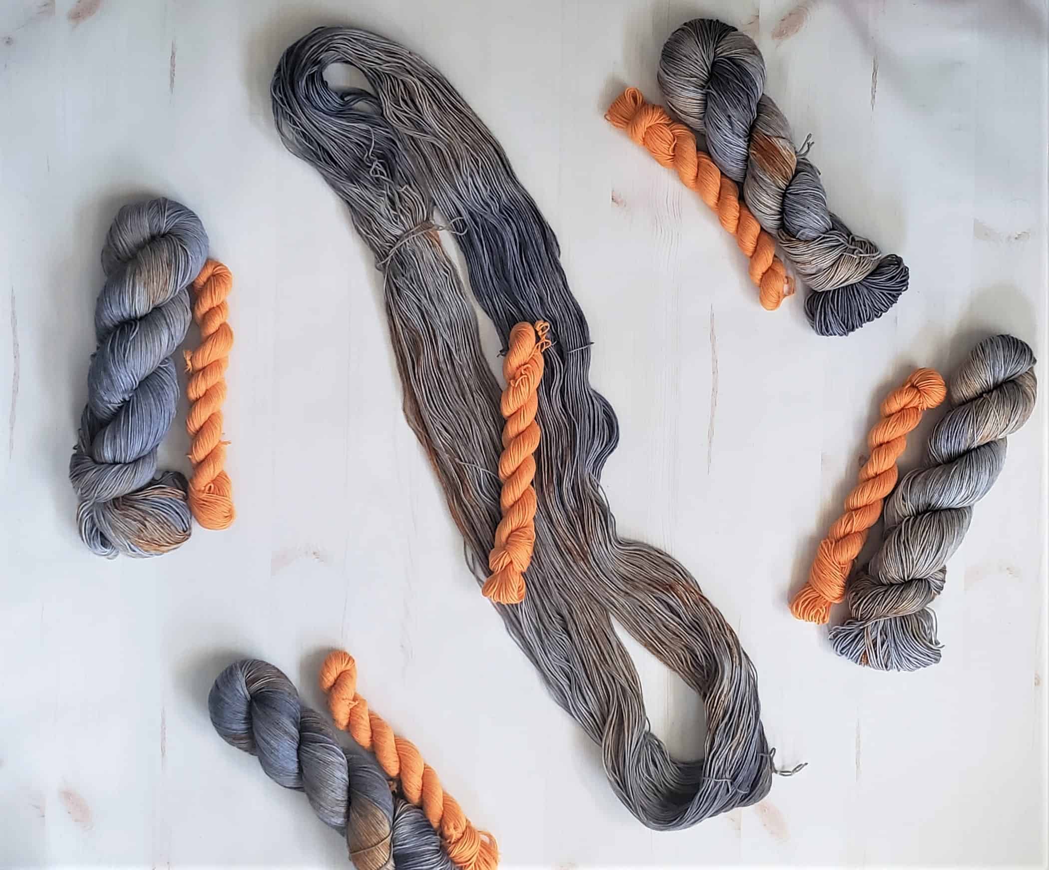 Gray yarn with orange mini skeins.