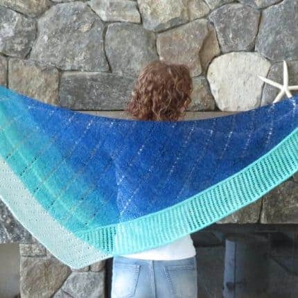 A triangular shawl with a fade of blue to gray.