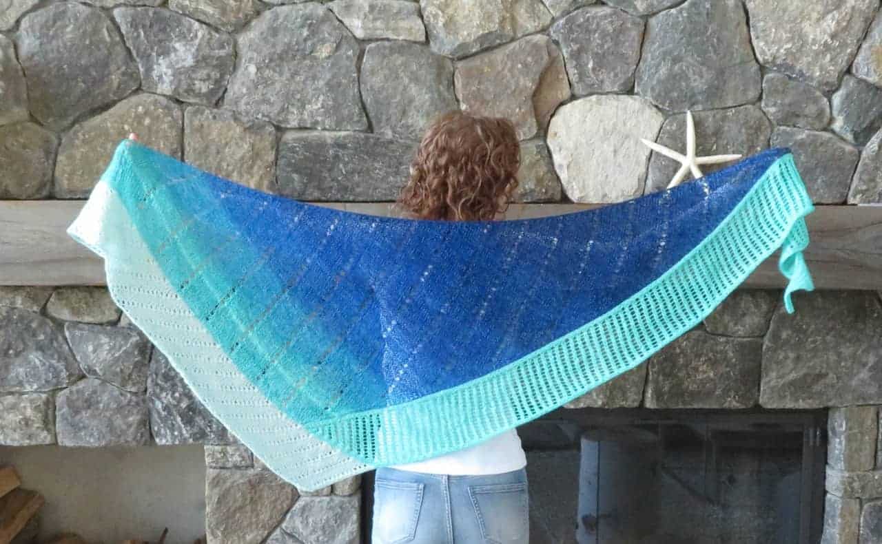 A triangular shawl with a fade of blue to gray.