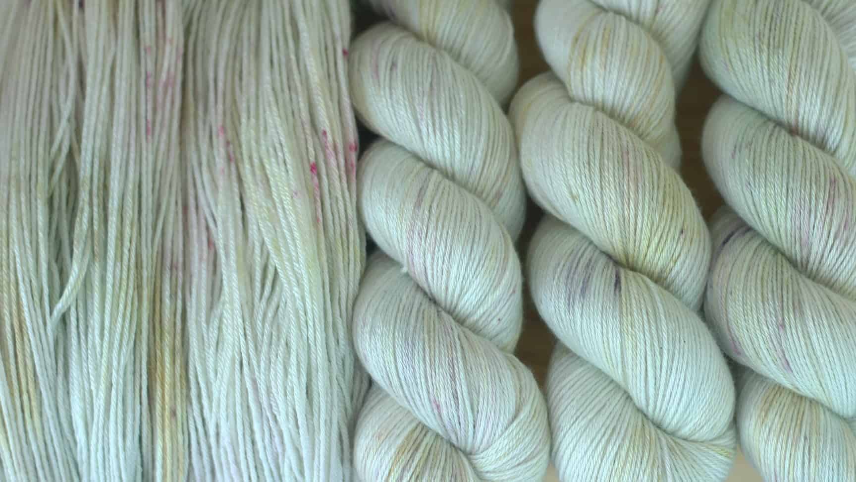 Cream yarn with pale pink, purple and gold speckles.