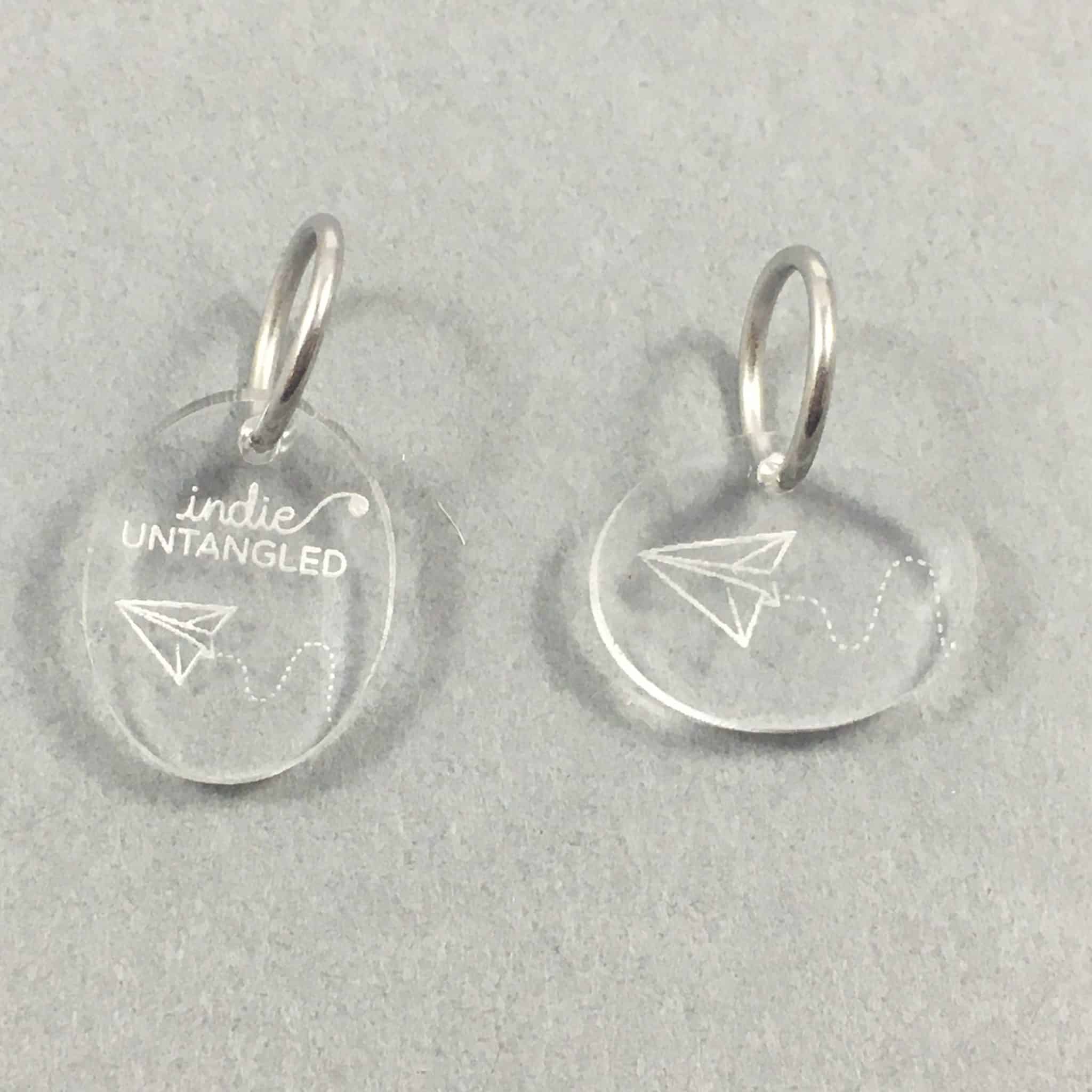 Clear stitch markers with paper airplanes.