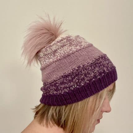 A plum and pink hat with a pink pom pom.