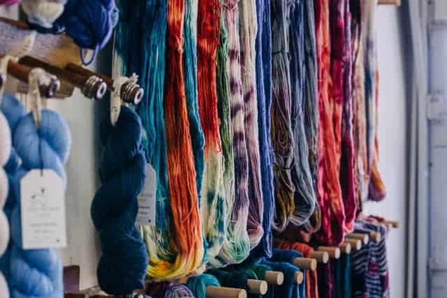 Colorful hanks of yarn hanging untwisted.