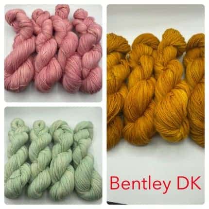 Skeins of pink, green and gold yarn.