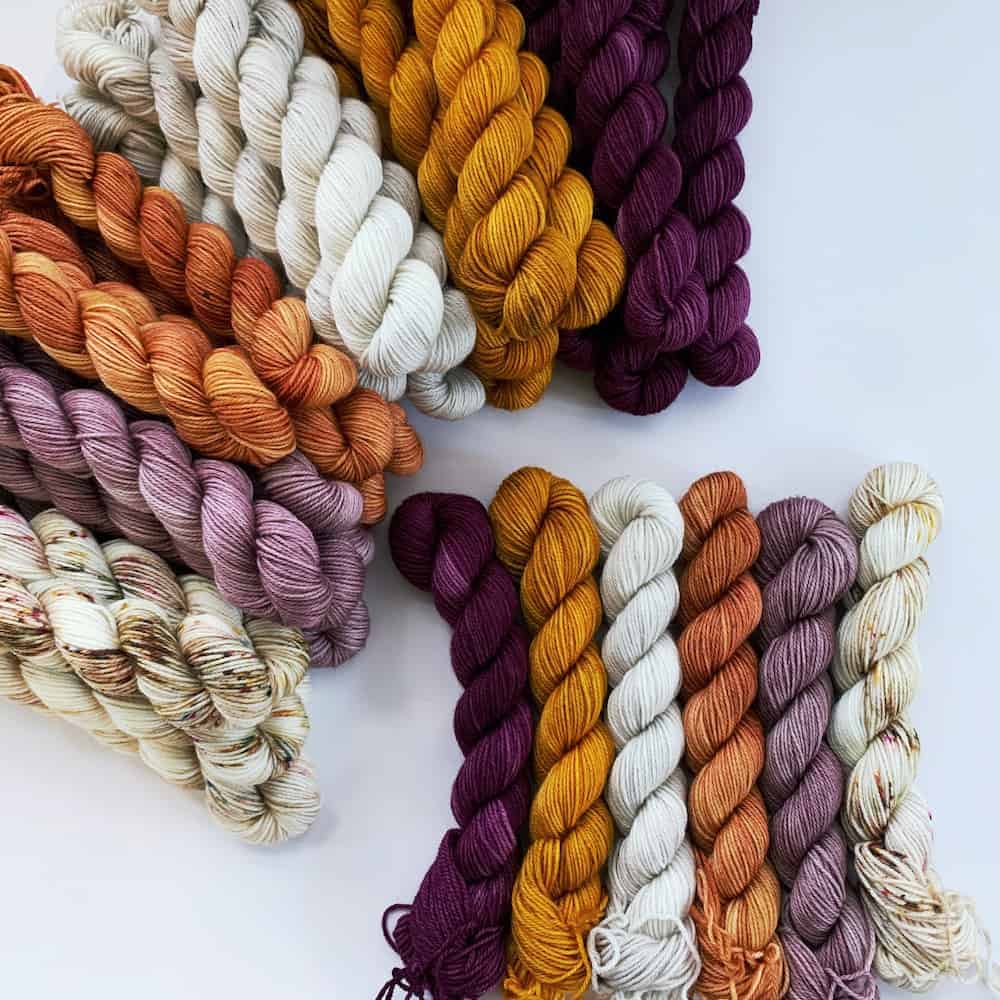 Skeins of orange, purple and white yarn.