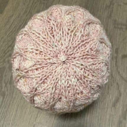 The crown of a pale pink textured hat.