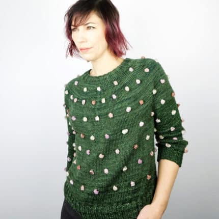 A green sweater with multicolored bobbles.