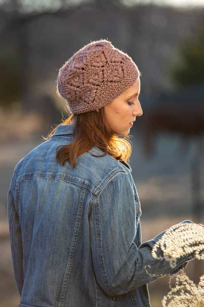 A dusky pink knit hat with a floral pattern.