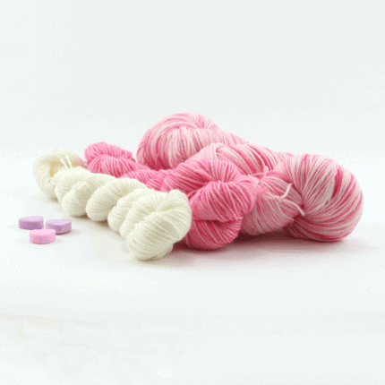 White and pink yarn with pink candy hearts.
