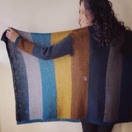 A blue, gray and gold striped sweater held out like a blanket.