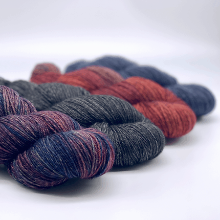 Skeins of purple, gray, red and blue yarn.