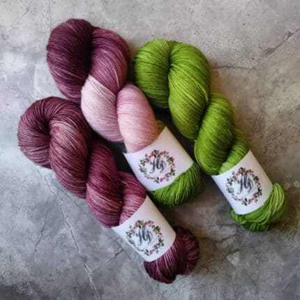 A trio of purple and green yarn.