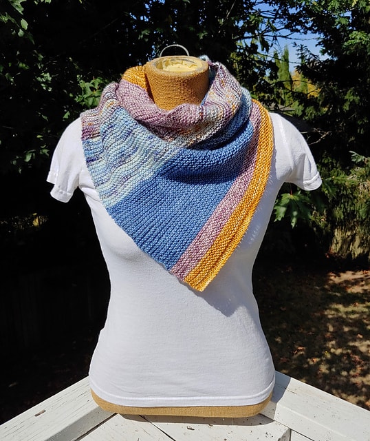 A blue, pink and yellow cowl on a dress form wearing a white T-shirt.