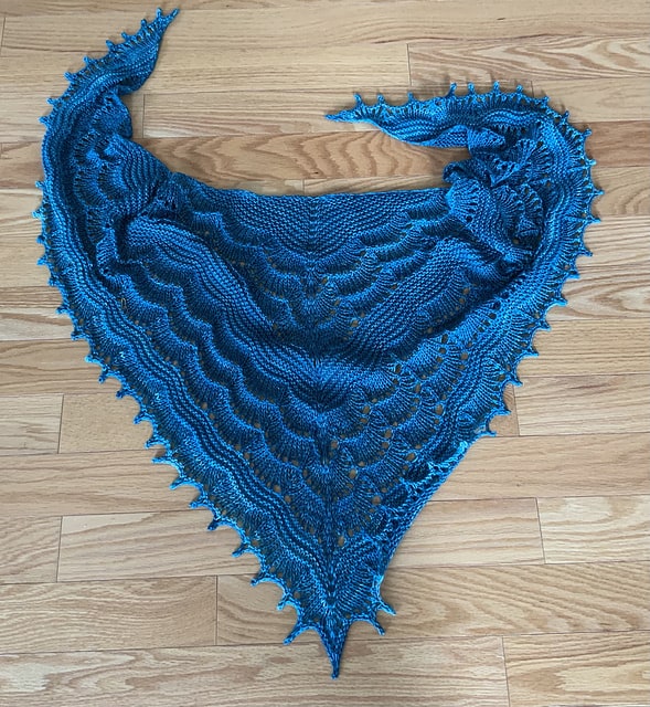 A bright blue triangular shawl.