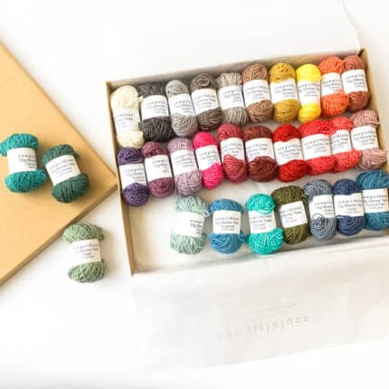 A box of colorful semisolid mini skeins of yarn.