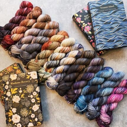 Skeins of speckled yarn with floral covered copies of the books Madame Bovary and Treasure Island.