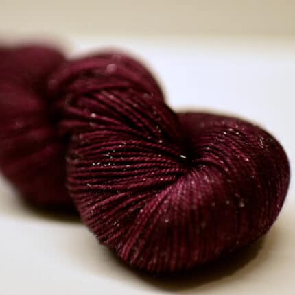 A skein of sparkly dark red yarn.
