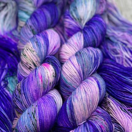 Bright violet, pink and teal variegated yarn with black speckles.