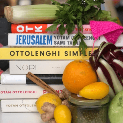 A pile of book by Yotam Ottolenghi and some fresh produce.