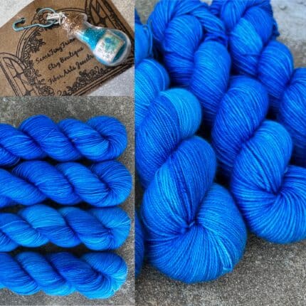 Sky blue skeins of yarn with matching blue bottle glitter stitch marker.