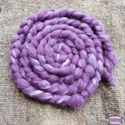 A braid of purple and white fiber, placed in the form of a wheel.