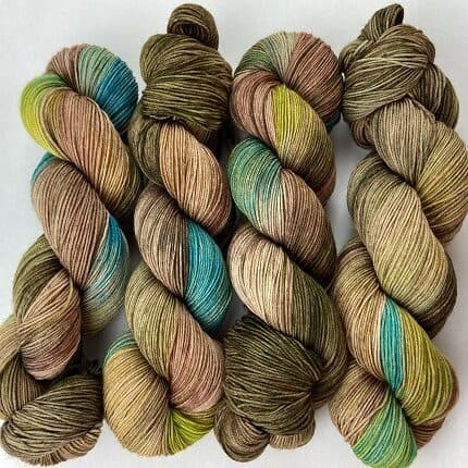 Skeins of yarn inspired by peahens with browns and subtle pops pf turquoise and green.