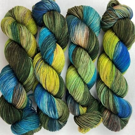 Skeins of bright peacock feather coloured yarns with browns, golds, and greens.