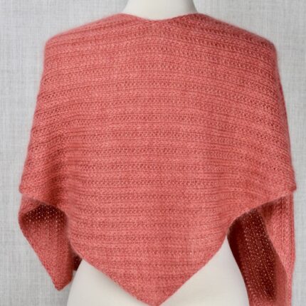 A salmon-colored ribbed shawl on a dress form.