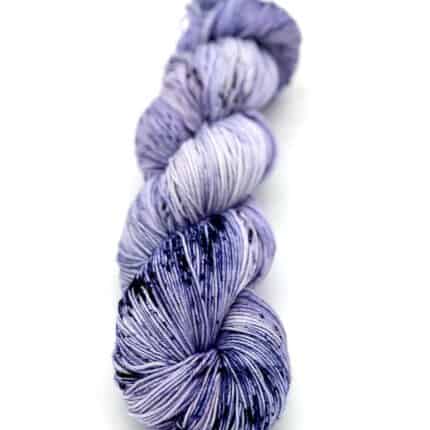 A blue-ish purple skein of yarn with blue speckles.