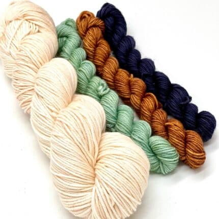 A light peach full size skein of yarn and three mini skeins, in DK weight. The mini skeins are safe green, brick yellow and Navy blue.