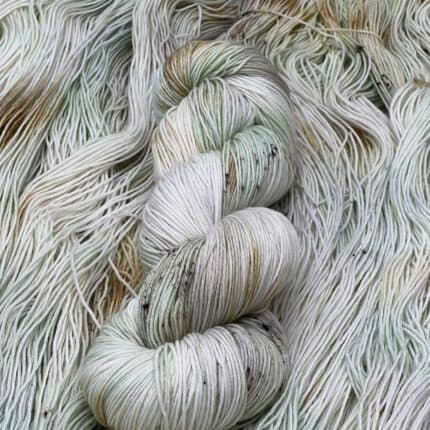 A very pale green and orange brown skein of yarn.