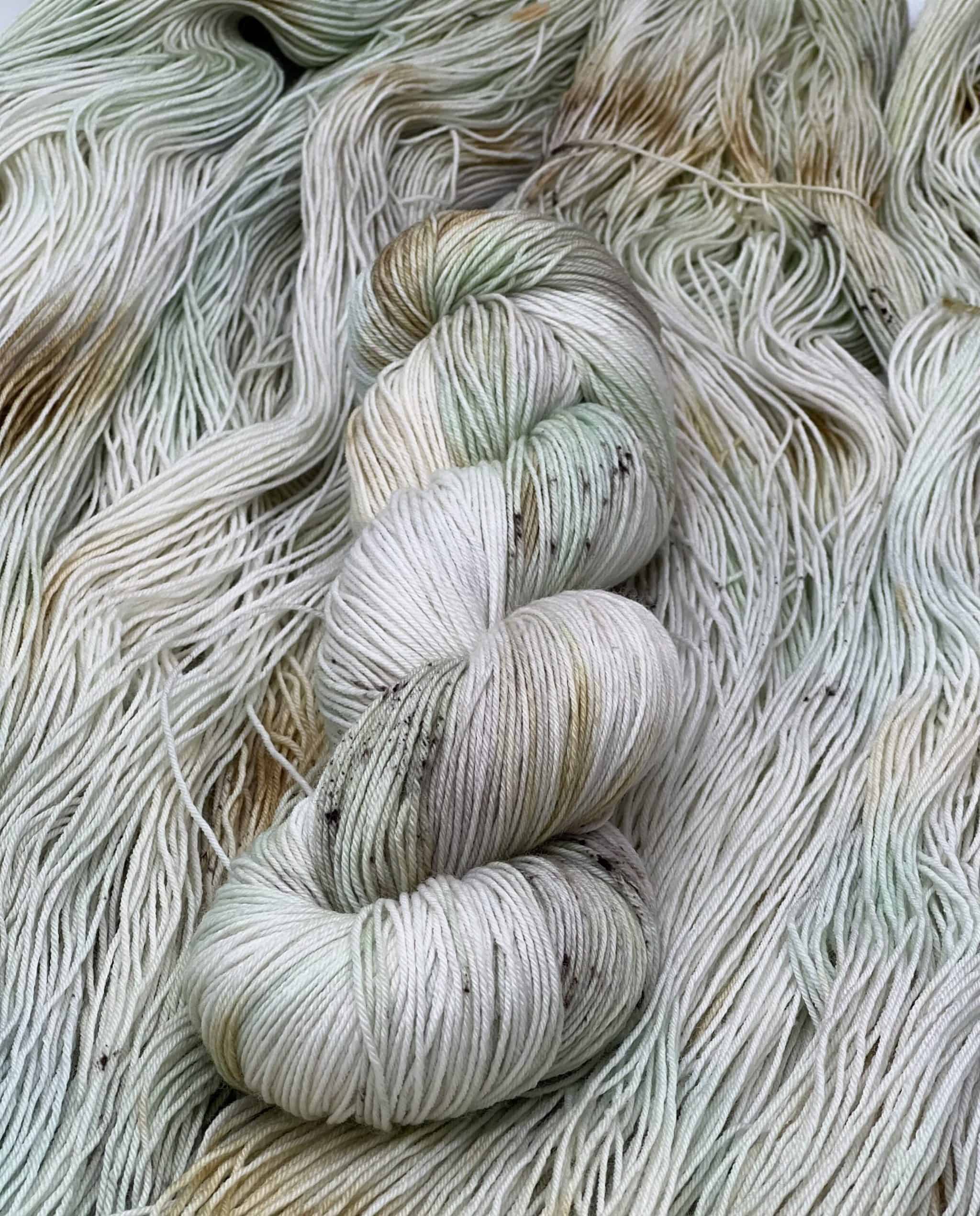 A very pale green and orange brown skein of yarn.